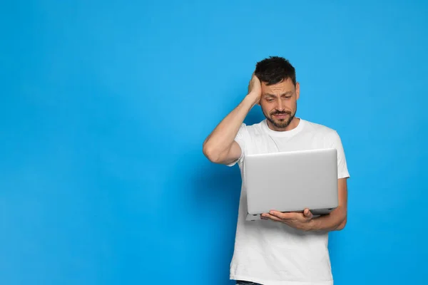 Confused Man Looking Laptop Light Blue Background Space Text — Stok Foto