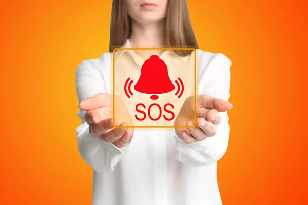 Young Woman Holding Virtual Icon Sos Orange Background Closeup — Φωτογραφία Αρχείου