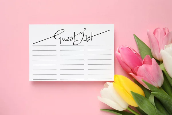 Beautiful tulips and guest list on pink background, flat lay