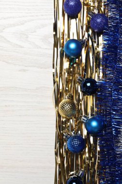 Beyaz ahşap arka planda parlak süsler ve noel topları, düz yatış. Metin için boşluk