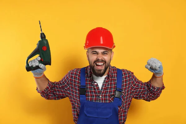 Emotional Worker Uniform Power Drill Yellow Background — Fotografia de Stock