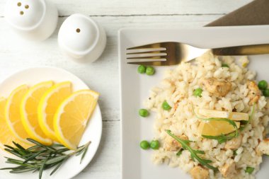 Beyaz ahşap masada servis edilen leziz tavuklu risotto.