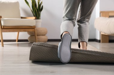 Evdeki halıya takılıp düşen kadın, yakın plan.