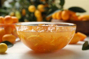 Kasede lezzetli kumkat reçeli ve beyaz ahşap masada taze meyveler.