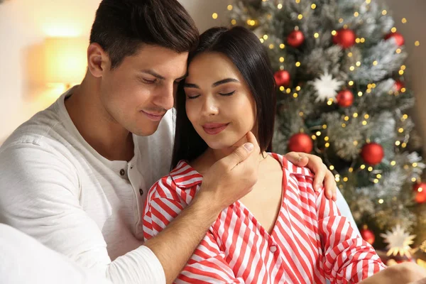 室内装飾されたクリスマスツリーの近くの幸せなカップル — ストック写真
