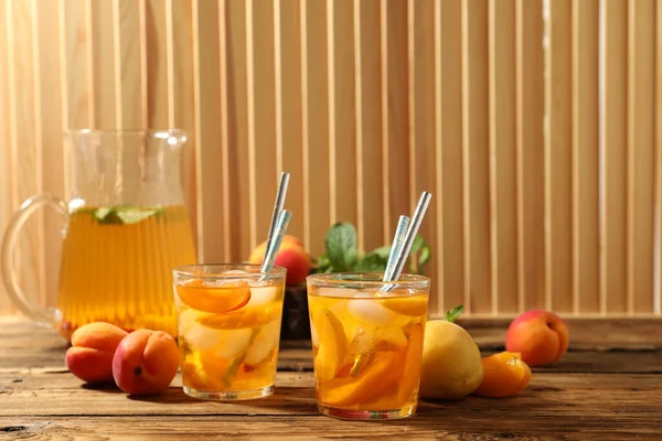 Delicious refreshing drink with apricot on wooden table