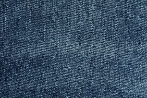 Texture of dark blue jeans as background, closeup