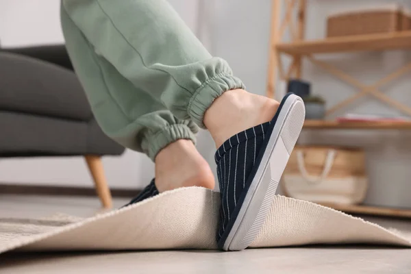 Man tripping over rug at home, closeup