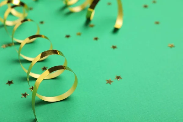 Shiny Golden Serpentine Streamers Confetti Green Background Closeup Space Text — Stock Fotó
