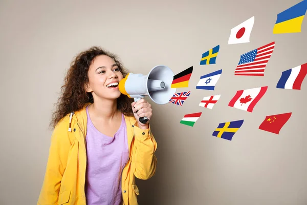 Portrait African American Interpreter Megaphone Flags Different Countries Beige Background — Stock Photo, Image