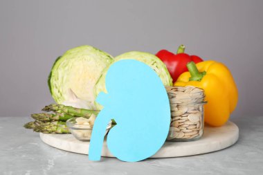 Böbrekten kesilmiş kağıt ve gri arka planda hafif mermer masa üzerinde farklı ürünler.