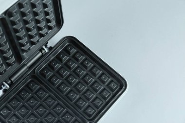 Işık arka planında elektrikli waffle makinesini aç, yukarıdan. Metin için boşluk