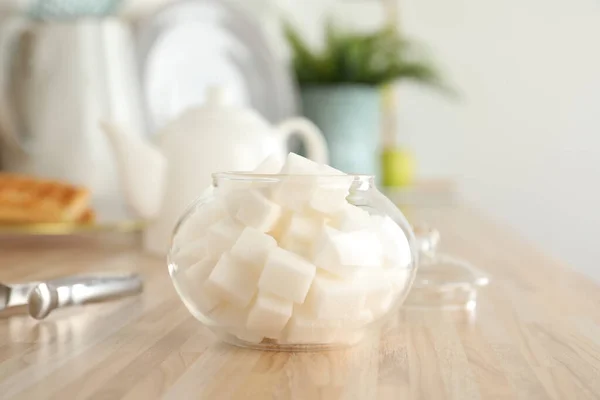 木製のテーブルの上に白い砂糖キューブとガラスボウル — ストック写真
