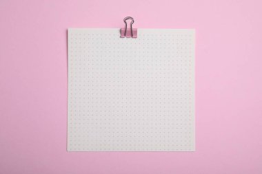 Pembe arka planda raptiyesi olan kağıt yaprağı, üst görünüm