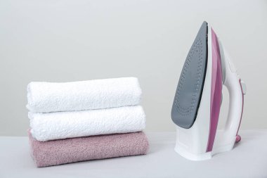 Masadaki modern demir ve temiz havlular açık gri arka plana karşı