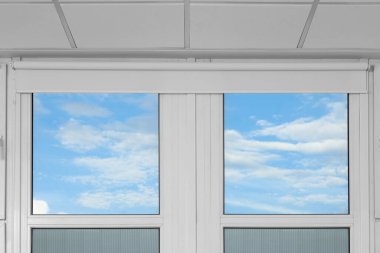 Plastic windows with white roller blinds indoors