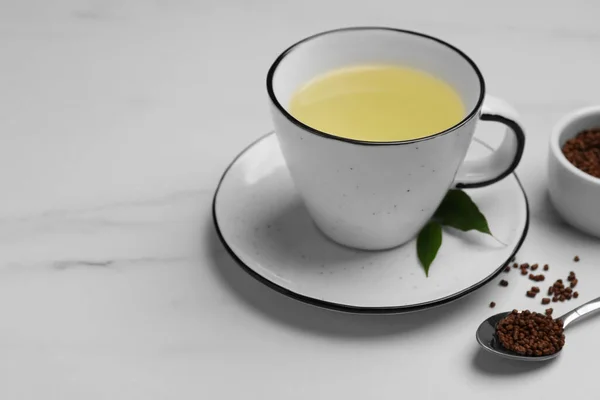 白い大理石のテーブルの上のそば茶と顆粒のカップ テキストのためのスペース — ストック写真