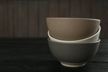 Siyah ahşap masada boş seramik kaseler, yazı için yer. Mutfak aletleri