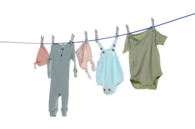 Colorful baby clothes drying on laundry line against white background