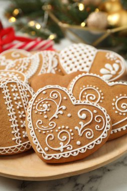 Tasty heart shaped gingerbread cookies in plate, closeup clipart