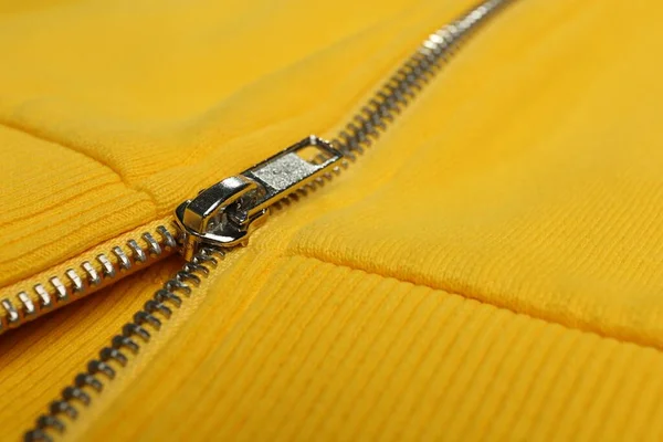 Yellow sweatshirt with zipper as background, closeup view