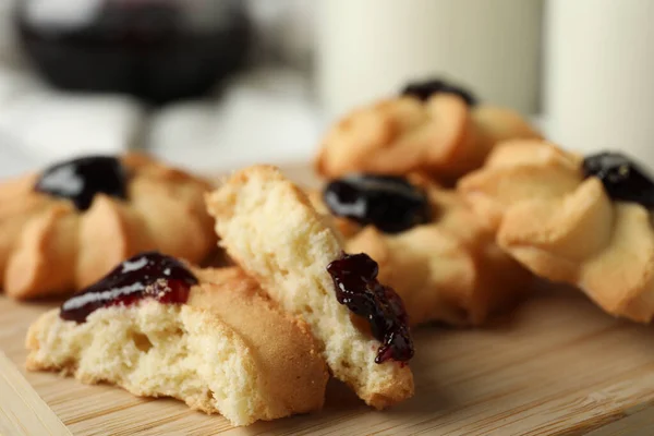 Tasty shortbread cookies with jam on table, closeup