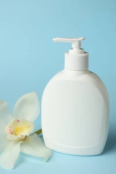 Açık Mavi Arkaplanda Bir Şişe Sıvı Sabun Çiçek — Stok fotoğraf