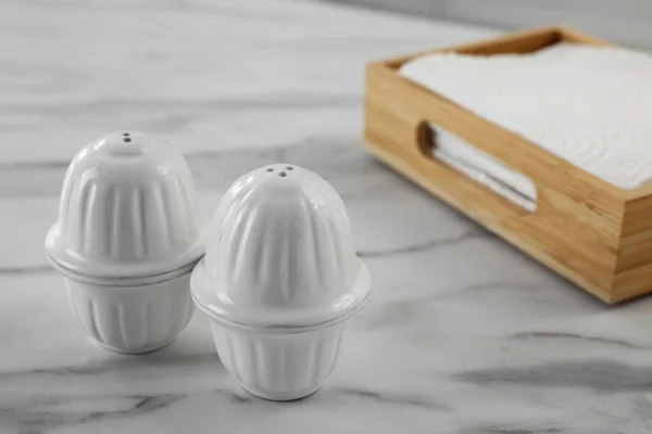 Keramiska Salt Och Peppar Shakers Nära Låda Servetter Vit Marmor — Stockfoto