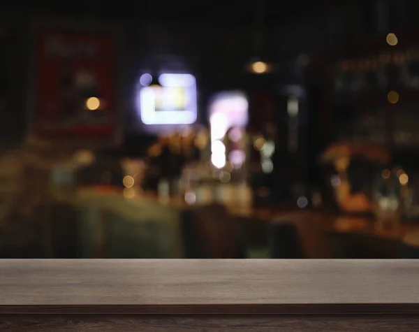 Empty wooden surface and blurred view of bar interior. Space for design