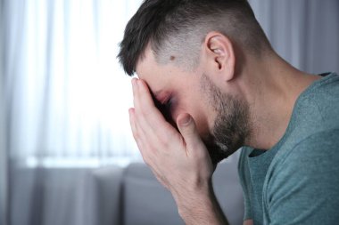 Evde yüzü morarmış bir adam, mesaj için yer var. Aile içi şiddet mağduru