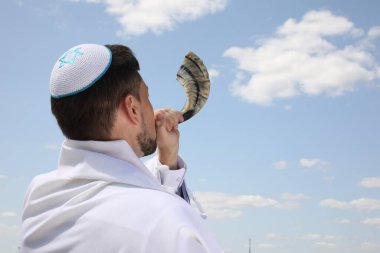 Kippah 'ta Yahudi bir adam ve açık havada Tallit esintisi yapıyor. Rosh Hashanah kutlaması