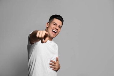 Gri arka planda gülen yakışıklı bir adam. Komik şaka.