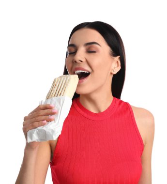 Beyaz arka planda lezzetli shawarma yiyen genç bir kadın.
