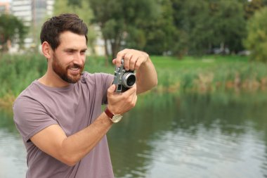 Kameralı adam dışarıda fotoğraf çekiyor, mesaj için yer var. İlginç bir hobi.