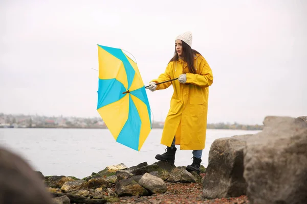 Woman Yellow Raincoat Umbrella Caught Gust Wind River — Stock Photo, Image