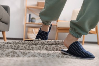 Man tripping over rug at home, closeup