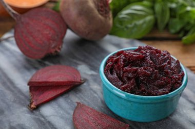 Lezzetli pancar püresi ve ahşap masadaki malzemelerle dolu bir kase.