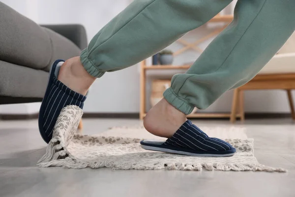 Man tripping over rug at home, closeup