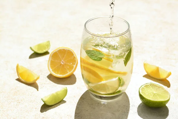 Pouring Water Glass Lemon Slices Mint Light Grey Table — Stok fotoğraf