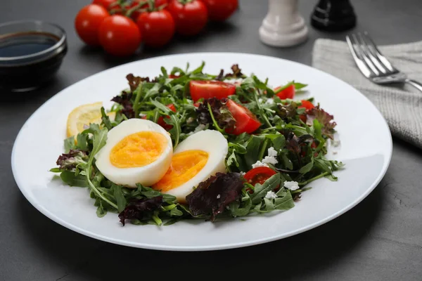 Delicious Salad Boiled Egg Arugula Tomatoes Black Table Closeup — Stockfoto