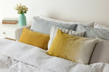 Güzel bir oda, rahat yatak ve papatya çiçekleri.