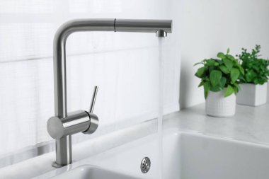 Stream of water flowing from tap in kitchen