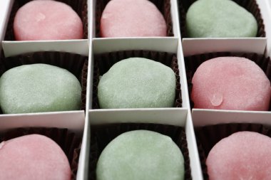 Arka plan olarak farklı lezzetli mochi 'leri olan bir kutu, yakın plan. Geleneksel Japon tatlısı