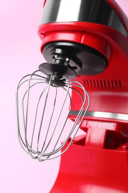 Modern red stand mixer on pink background, closeup