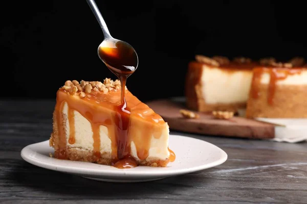 Pouring Caramel Sauce Delicious Piece Cheesecake Walnuts Black Marble Table — Stock Photo, Image