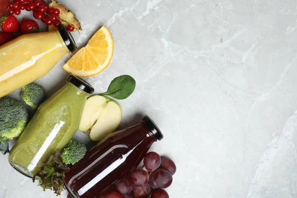Flaschen Mit Köstlichen Säften Und Frischen Früchten Auf Einem Marmortisch — Stockfoto