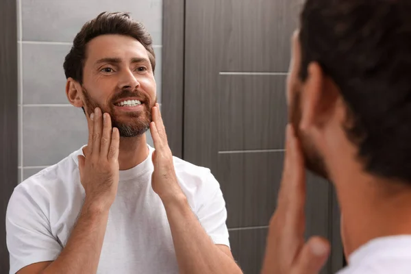 Sorrindo Barbudo Homem Olhando Para Espelho Banheiro — Fotografia de Stock