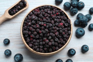 Freeze dried and fresh blueberries on white wooden table, flat lay