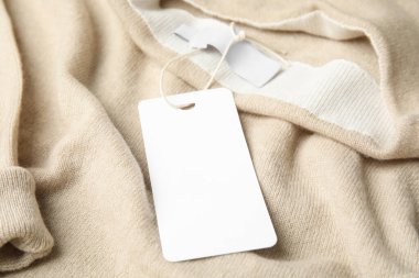 Etiketli sıcak bej kaşmir kazak, yakın plan.