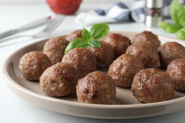 Lezzetli pişmiş köfteler, tabakta fesleğen, yakın plan.